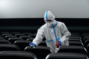 Man in protective suit disinfect cinema hall.